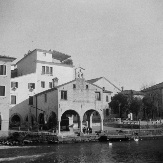 A river with an old building in black and white